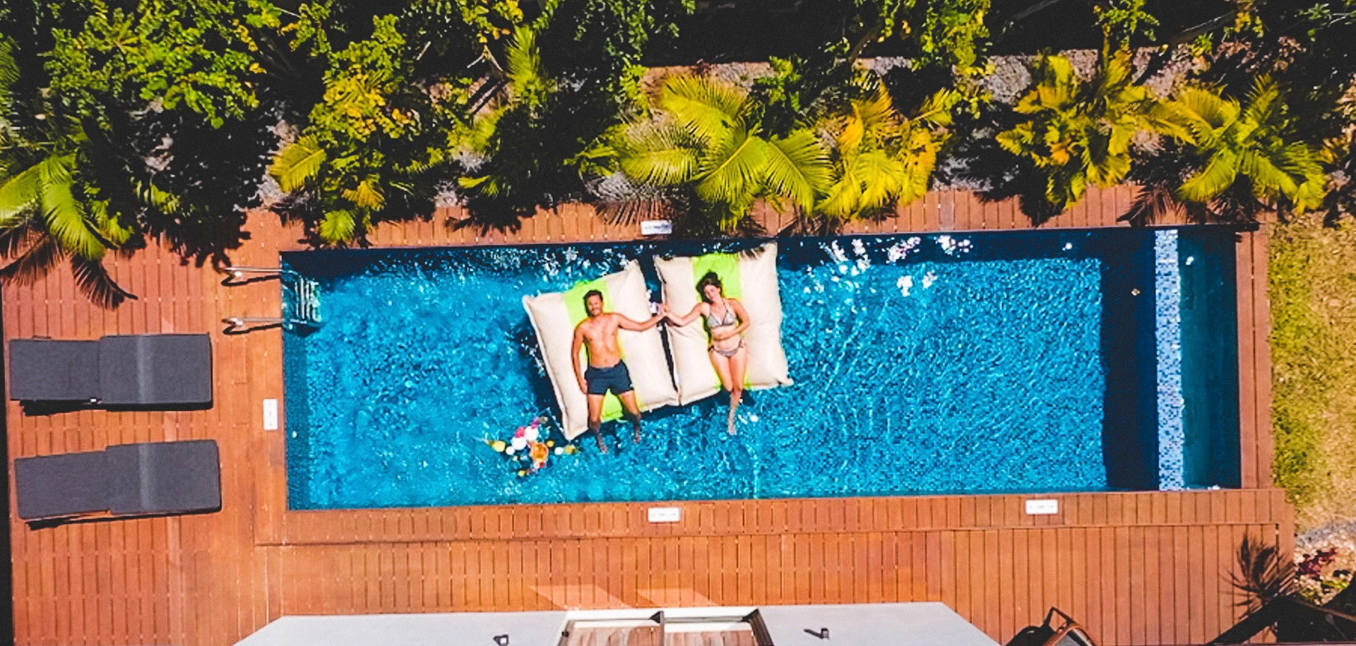 Aerial view of the main pool at Wonders Beach with two guests enjoying the sun