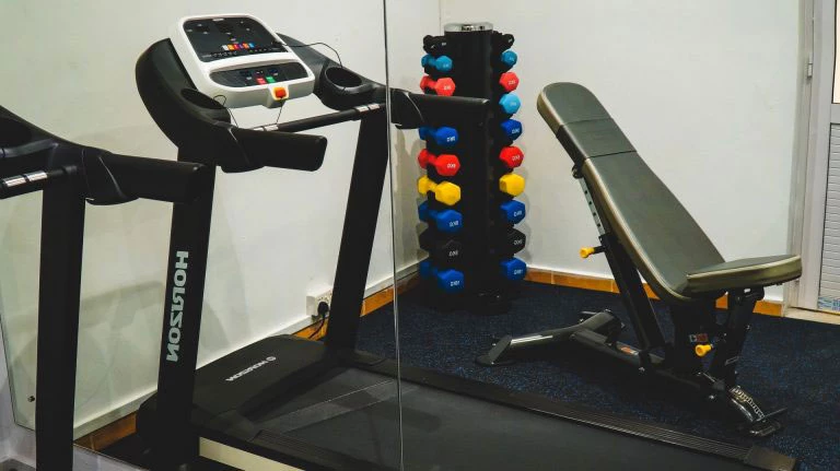 Fitness room at Wonders Beach equipped with cardio machines and free weights