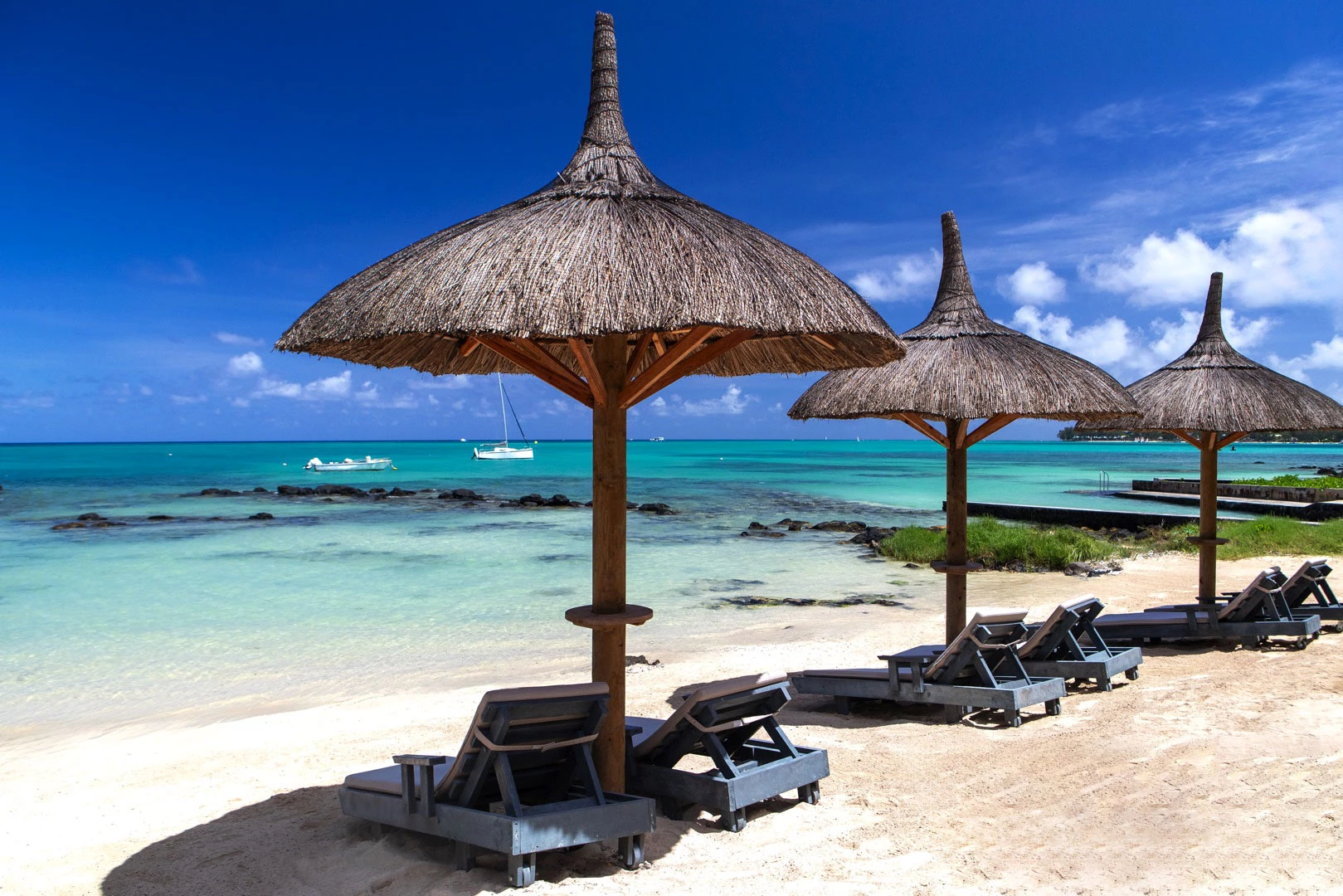 Wonders Beach Boutique beachfront with thatched umbrellas and turquoise sea.